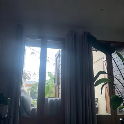 Une fenêtre à contre-jour derrière des rideaux sombres